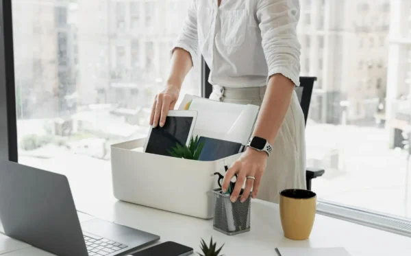 Uma profissional retira os pertencentes da mesa de trabalho após o pedido de demissão.