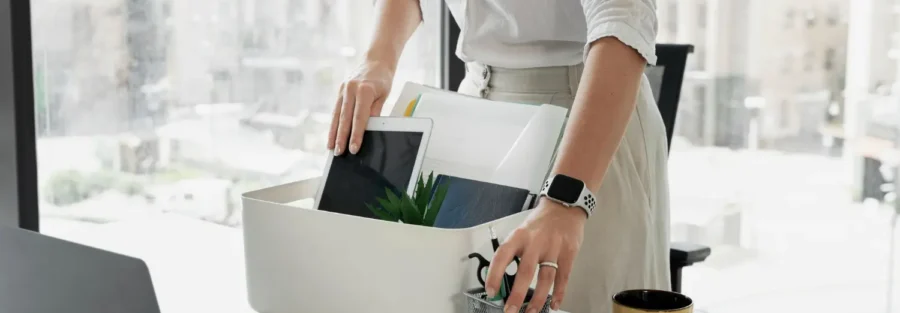 Uma profissional retira os pertencentes da mesa de trabalho após o pedido de demissão.