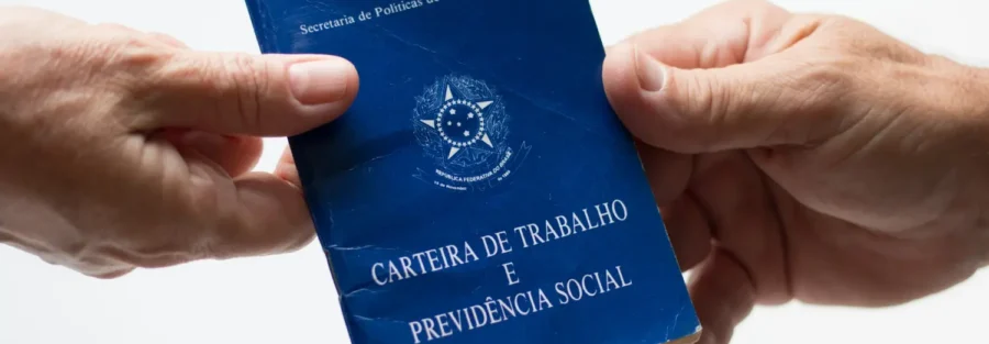 Imagem de duas pessoas segurando uma carteira de trabalho, simbolizando quem tem direito ao seguro desemprego.