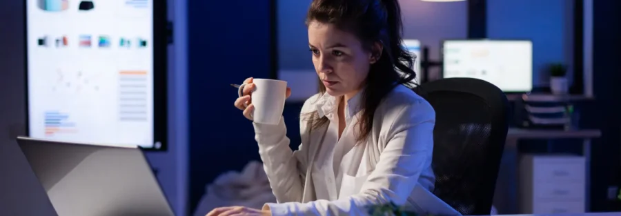 Imagem de uma mulher trabalhando à noite no escritório, reforçando a importância do adicional noturno.